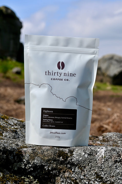 A bag of Thirty Nine coffee Eighteen blend beans in front of the cow and calf rocks in Ilkley