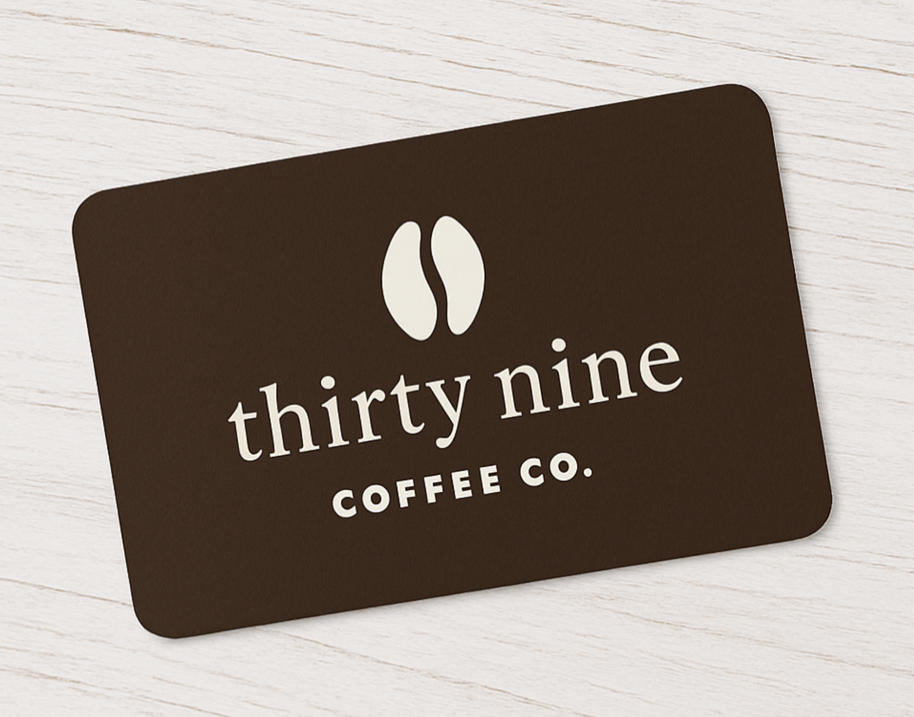Black gift card with 'thirty nine COFFEE CO.' text on a light wooden surface